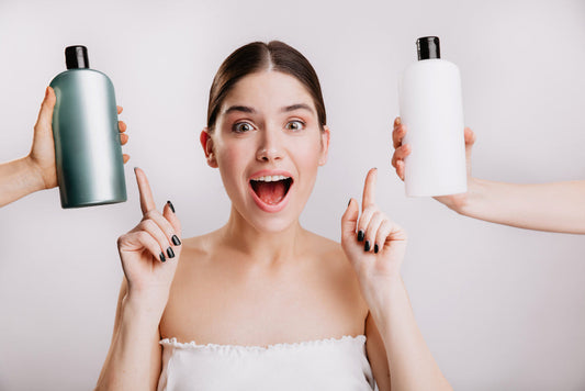 Excited woman pointing to two hair product bottles held up beside her