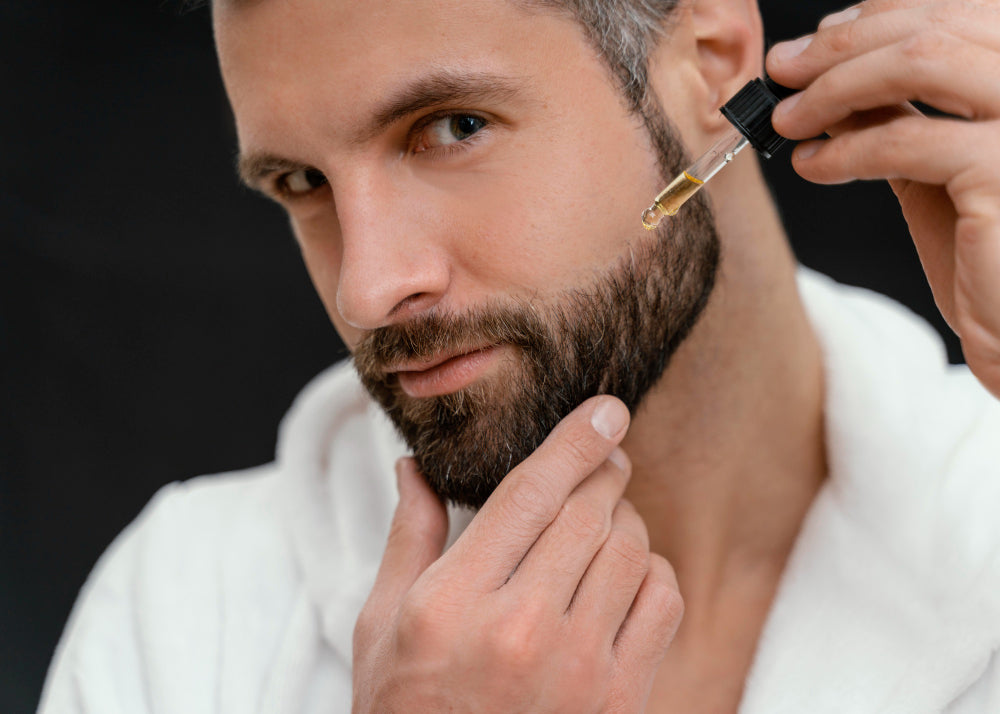 Man applying Organic Beard Growth Oil with a dropper to his beard