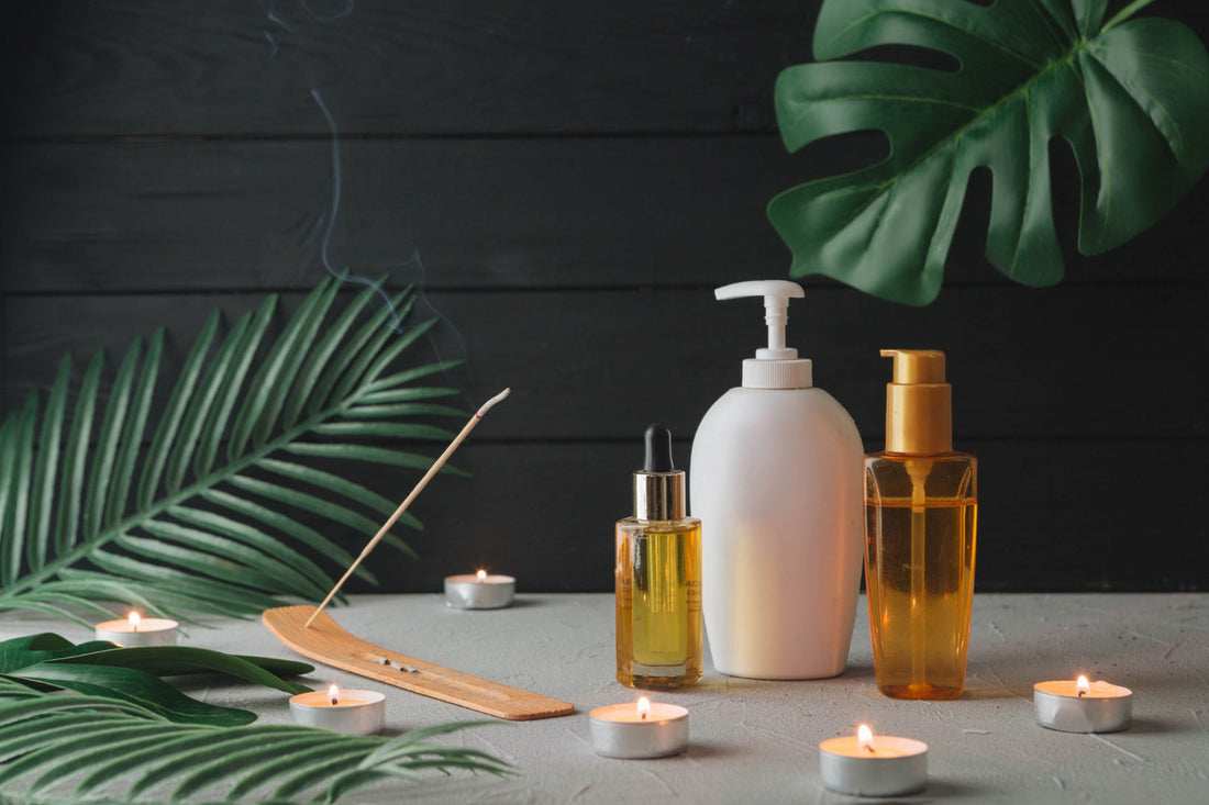 Argan oil shampoo and conditioner bottles styled with candles and tropical leaves