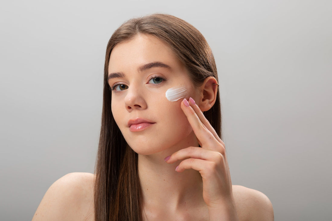 Woman applying a swipe of face moisturizer to her cheek for dry skin