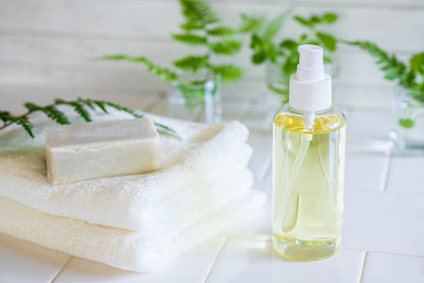 Sulfate-free facial cleanser bottle and soap bar on folded white towels
