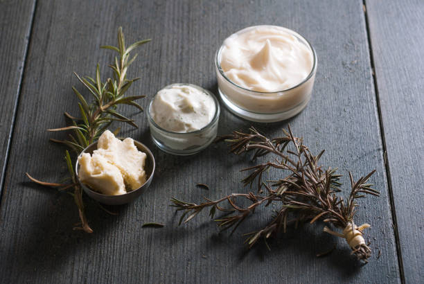 Jars of whipped body butter with rosemary sprigs and shea butter chunks
