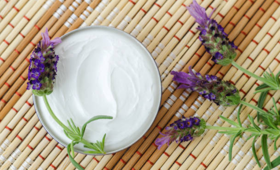 Tin of body butter moisturizer styled with fresh lavender sprigs