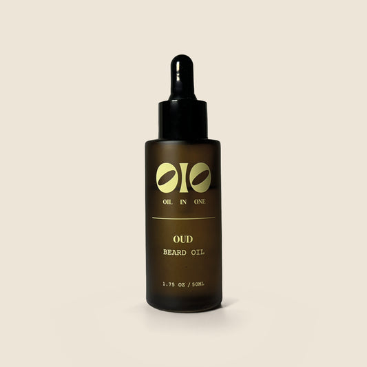Bottle of Oud Beard Oil with dropper on a beige background